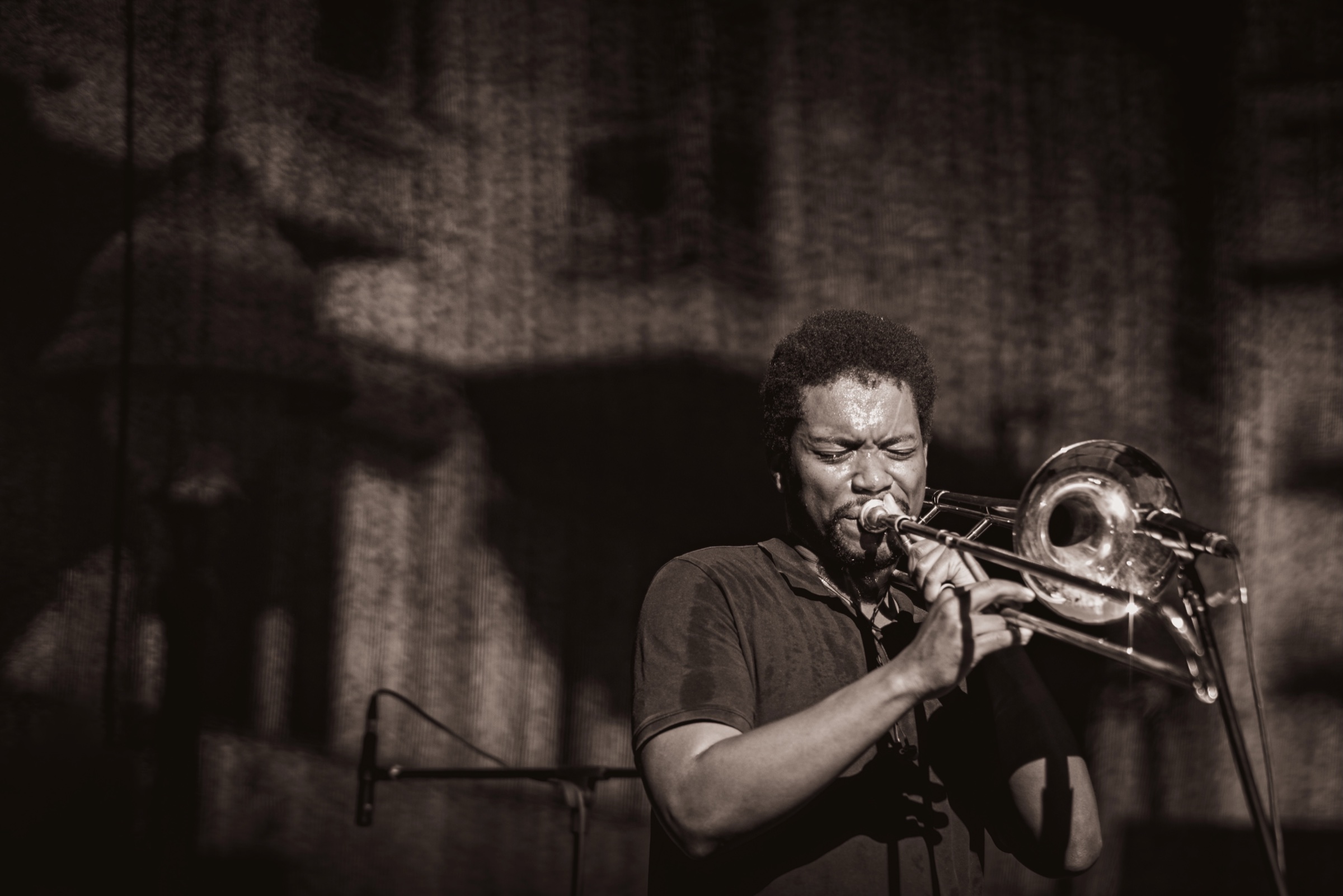 Trombone player performing under dramatic stage light