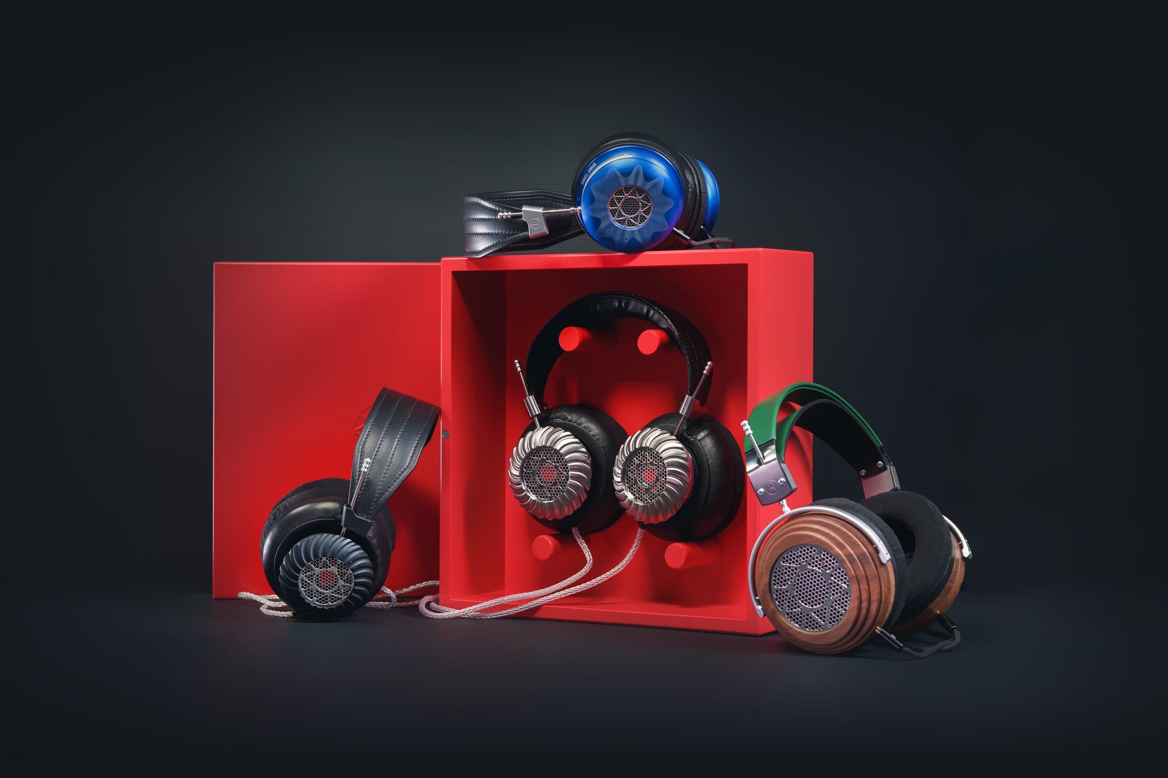 A collection of high-end headphones arranged around red studio plinths